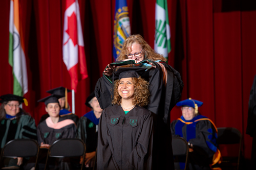 Para Bassiri MPH '19 receives her master's hood from Dartmouth Institute Associate Director of Education Karen Ashley.